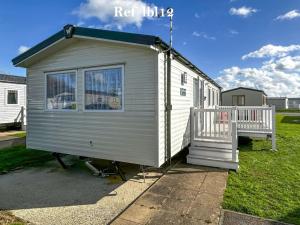 una pequeña casa blanca pequeña con porche en Parkdean Resort Camber Sands sleeps 8 Pet Friendly - ref-lbl12, en Camber