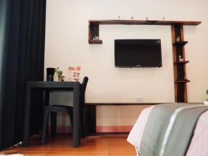 a room with a table and a tv on a wall at JLB Resort and Tours,Mango Rooms in Valdez