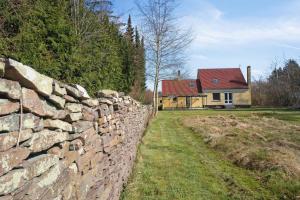 un mur en pierre devant une maison dans l'établissement Rummeligt Feriehus På Stor Naturgrund, à Langedeby 7 autres photos