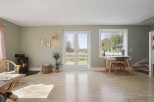 un salon vide avec une porte et une table dans l'établissement Rummeligt Feriehus På Stor Naturgrund, à Langedeby