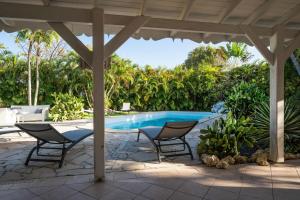 a patio with a table and chairs and a pool at Villa Secrète in Saint-François