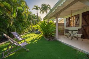 a patio with chairs and a table on a lawn at Villa Secrète in Saint-François +23 photos