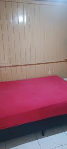 a bed in a room with a pink mattress at Casa de Veraneio in Passo De Torres +4 photos