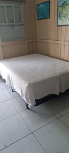 a white bed sitting on top of a room at Casa de Veraneio in Passo De Torres