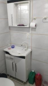 a small bathroom with a sink and a mirror at Casa de Veraneio in Passo De Torres