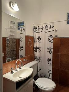 een badkamer met een wastafel, een toilet en een douchegordijn bij LOS OLIVARES. SAN LORENZO in Salta