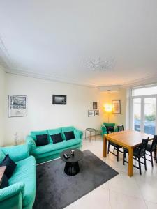 a living room with a blue couch and a table at La Maison du Bonheur - 10 people - Close to Paris in Noisy-le-Grand