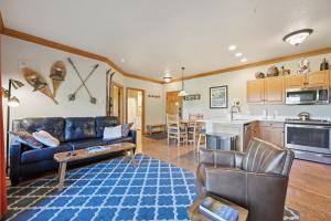 ein Wohnzimmer mit einer blauen Couch und einer Küche in der Unterkunft Hidden River Lodge 5940 by Summit County Mountain Retreats in Keystone