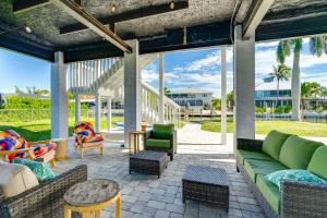 an outdoor patio with green couches and chairs at Boat Dock and Patio Canal-Front St James City Home! in Saint James City