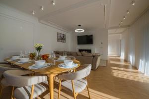 ein Esszimmer mit Tisch und Stühlen und einer Couch in der Unterkunft Moonlight City Villa in Alba Iulia