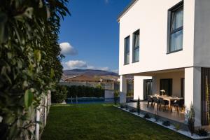 ein weißes Haus mit einem Esstisch im Garten in der Unterkunft Moonlight City Villa in Alba Iulia