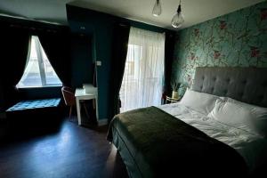 ダンガーバンにあるDog-friendly Seaview Apartmentのベッドと机と窓のある寝室