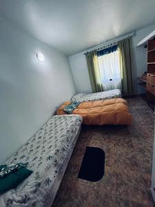 ein Schlafzimmer mit zwei Betten und einem Fenster in der Unterkunft San Javier Cottage in Yerba Buena