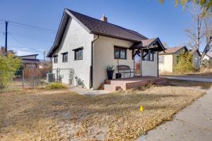 une petite maison blanche avec une véranda et un banc dans l'établissement 2 Mi to Dtwn Colorado Springs Gem with Hot Tub!, à Roswell