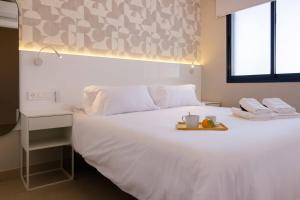 サンアグスティンにあるAmapola Moon - Calidad y disfrute en primera linea de playaの白いベッド(フルーツのトレイ付)