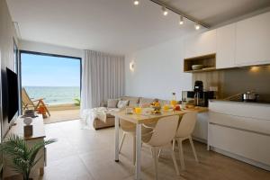サンアグスティンにあるAmapola Moon - Calidad y disfrute en primera linea de playaのキッチンとリビングルーム、テーブルと椅子、そして海