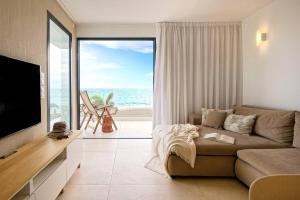 サンアグスティンにあるAmapola Moon - Calidad y disfrute en primera linea de playaのソファと大きな窓のあるリビングルーム