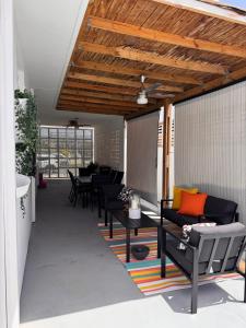 eine Terrasse mit Sofas, einem Tisch und Stühlen in der Unterkunft AGA House Vacation Rental in Carolina