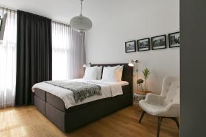 a bedroom with a large bed and a chair at Bacán Bed & Breakfast in The Hague