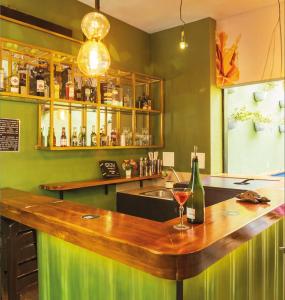 a green kitchen with a bar with a bottle of wine at Seven Nights Hostel Cartagena in Cartagena de Indias +96 photos