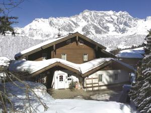 a house covered in snow with a mountain in the background at Apartments in Dienten am Hochkönig 225 in Dienten am Hochkönig
