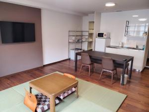 een woonkamer met een tafel en een keuken bij City Pension Zem in Tokyo