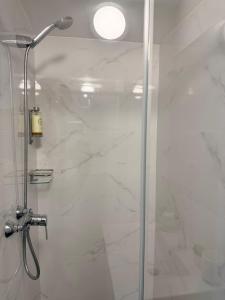 a bathroom with a shower with a glass door at Solmare Suites by Atlas in Albufeira +29 photos