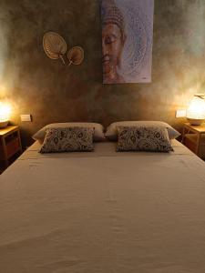 een slaapkamer met een groot bed met twee kussens bij Pangea - Asia in Trani