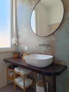 een badkamer met een grote witte wastafel en een spiegel bij Pangea - Asia in Trani