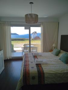 Departamento del Lago II في سان كارلوس دي باريلوتشي: غرفة نوم بسرير كبير مع نافذة كبيرة