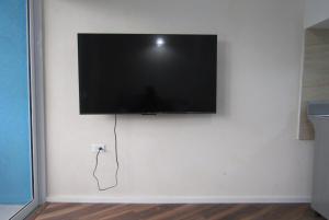 ein Flachbildfernseher, der mit einem Kabel an der Wand hängt in der Unterkunft 104 Batts Rock Beach Condos near UWI in Saint Michael