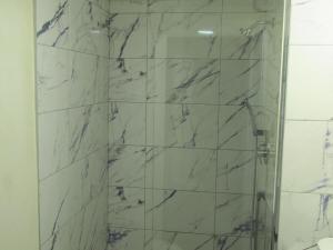 ein Badezimmer mit Dusche und Marmorfliesen in der Unterkunft 104 Batts Rock Beach Condos near UWI in Saint Michael + 20 Fotos