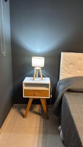 a nightstand with a lamp on it next to a bed at Ballester apart piscina in Villa Ballester +8 photos