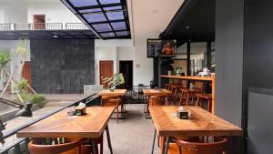 un restaurante con mesas y sillas de madera en The Baliem Hotel, en Jimbaran