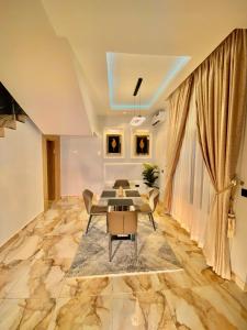 una sala de estar con una mesa y sillas en Serenova Suites, en Abuja