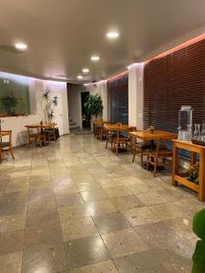 un restaurante con mesas de madera y sillas de madera en Hotel La Vista, en San Martín Texmelucan de Labastida