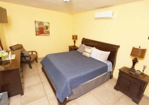 a bedroom with a bed and a table and a chair at Rocky Point Casa Mango w Pool Walk to Beach in Ciudad Constitución +48 photos
