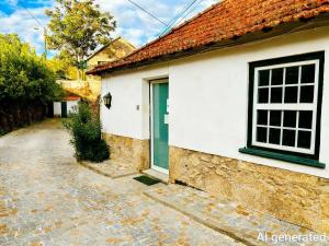 een wit huis met een groene deur in een straat bij Casa Do Refugio Guest House in Covilhã