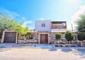 a brick house with a garage and trees at Rocky Point Casa Mango w Pool Walk to Beach in Ciudad Constitución