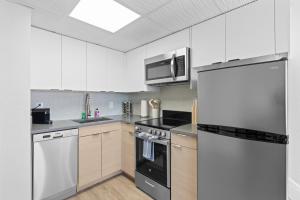 a kitchen with stainless steel appliances and white cabinets at Astral Desert Retreats in Mesa