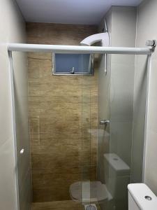 a bathroom with a glass shower with a toilet at Esquina 8 Apart in São José +25 photos