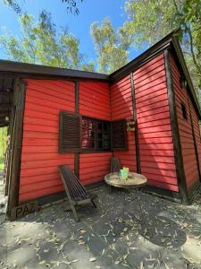 a red building with two chairs and a table at Galilea in San Miguel del Monte