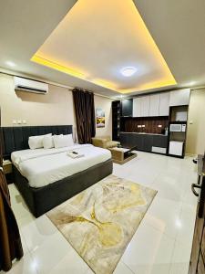a bedroom with a large bed and a living room at May Gold Luxury Apartments in Benin City