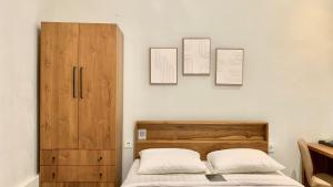 ジンバランにあるBaliem CoLivingのベッドルーム1室(ベッド1台付)が備わります。壁に3枚の写真が飾られています。