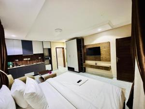a hotel room with a bed and a television at May Gold Luxury Apartments in Benin City