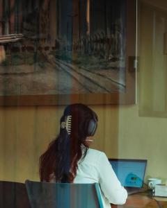 Eine Frau mit Kopfhörern sitzt an einem Schreibtisch mit einem Laptop. in der Unterkunft Hostik Hostal in Mérida + 61 Fotos