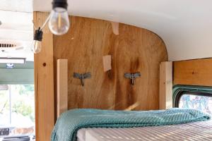 a bedroom with a bed with a wooden headboard at Magic Bus on river w/hot tub at Smuggler's Notch in Morses Mill +26 photos