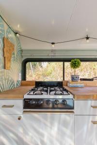 a kitchen with a stove top in an rv at Magic Bus on river w/hot tub at Smuggler's Notch in Morses Mill