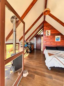 a bedroom in a log cabin with a bed and a tv at Terevaka Lodge Rapa Nui in Hanga Roa