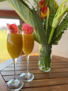 two wine glasses sitting on a table with a vase of flowers at Terevaka Lodge Rapa Nui in Hanga Roa +4 photos